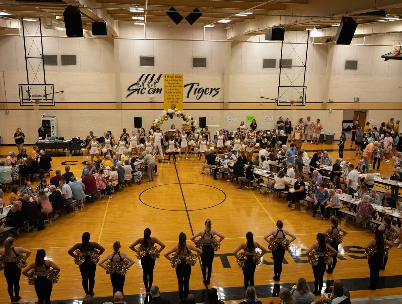 Cheerleaders and dance team at CHS pep rally under Sic 'em Tigers banner